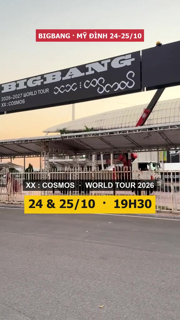 Cổng sân vận động Mỹ Đình treo banner BIGBANG 2026–2027 World Tour XX:COSMOS, cần cẩu đang lắp pano, biển vàng ghi 24 & 25/10 19:30