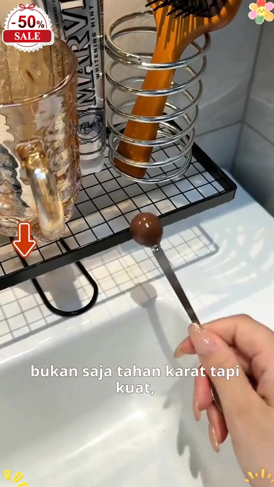 Rak grid hitam dengan pemegang berus berlingkar dan cawan di tepi sinki