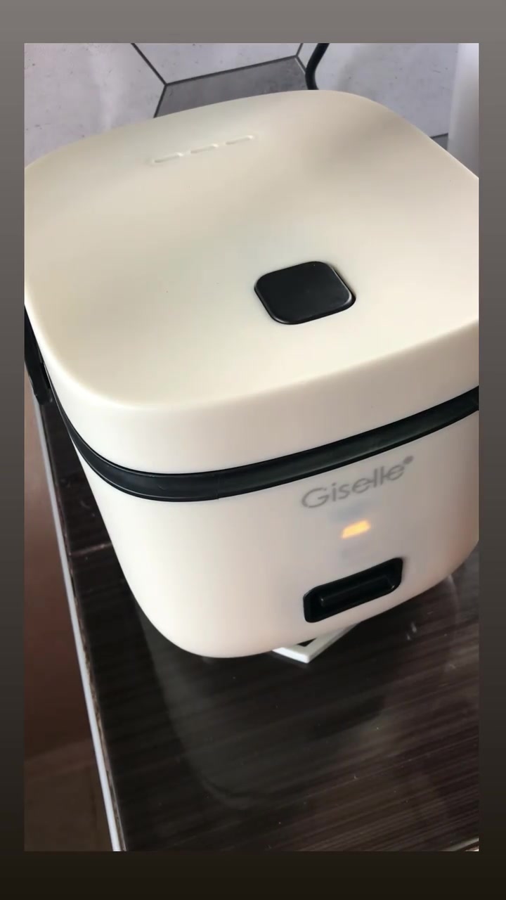 Rice cooker mini berwarna putih dengan lampu penunjuk keep warm menyala di bahagian hadapan