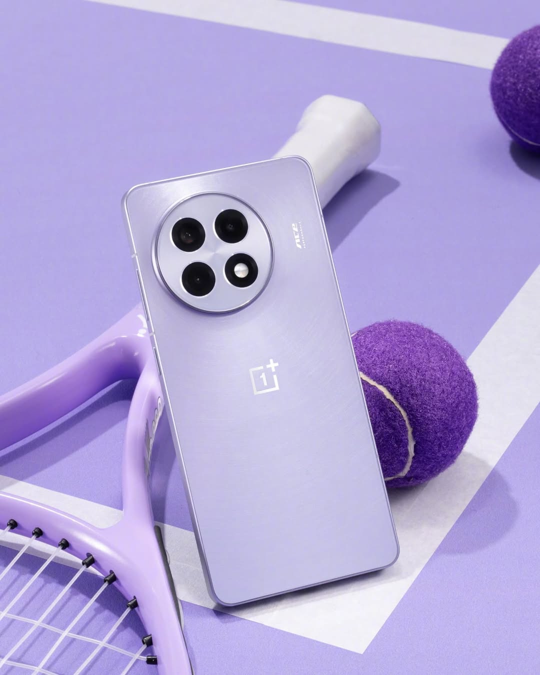 OnePlus Ace 5 Pro màu tím nhạt tựa vào cán vợt tennis trên nền tím, nổi bật cụm camera tròn bốn ống kính