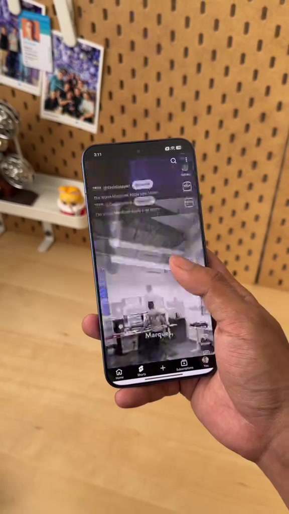 Xiaomi 17T Pro dipegang satu tangan menunjukkan skrin hadapan di hadapan dinding papan pasak