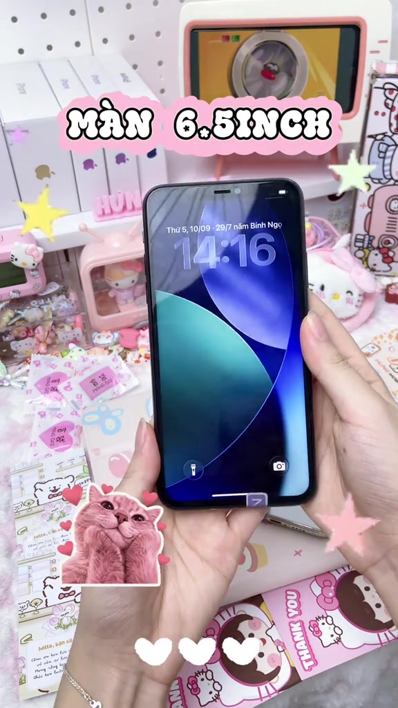 Một tay cầm chiếc iPhone mở màn hình khóa hiện đồng hồ, phía trên có dòng chữ màn 6.5inch
