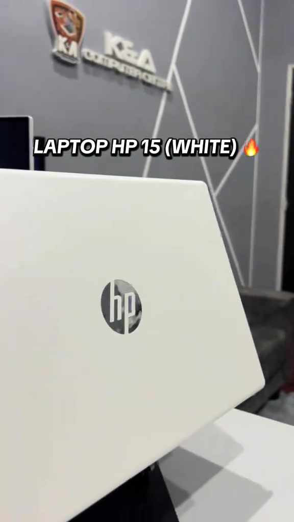 Tutup belakang laptop HP 15 warna putih dengan logo HP, dirakam dalam kedai komputer