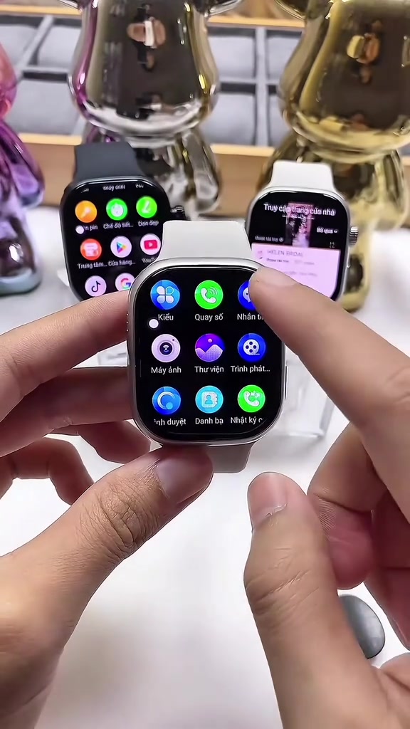 Đồng hồ thông minh mặt vuông kiểu dáng giống Apple Watch hiển thị menu tiếng Việt với icon Quay số, Danh bạ, Máy ảnh, Trình phát