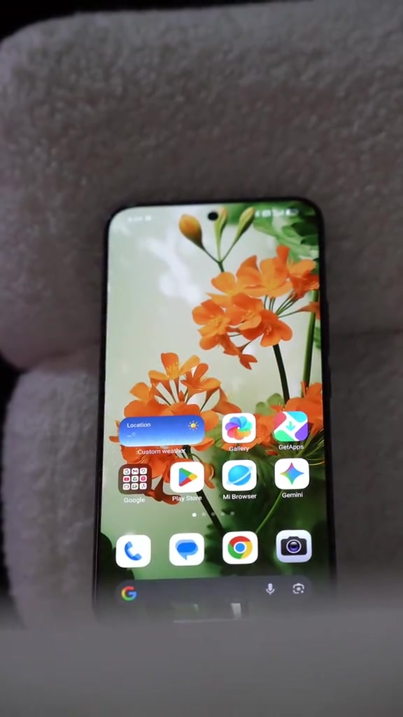 Skrin hadapan Xiaomi 17T Pro dengan wallpaper bunga dan deretan ikon app HyperOS