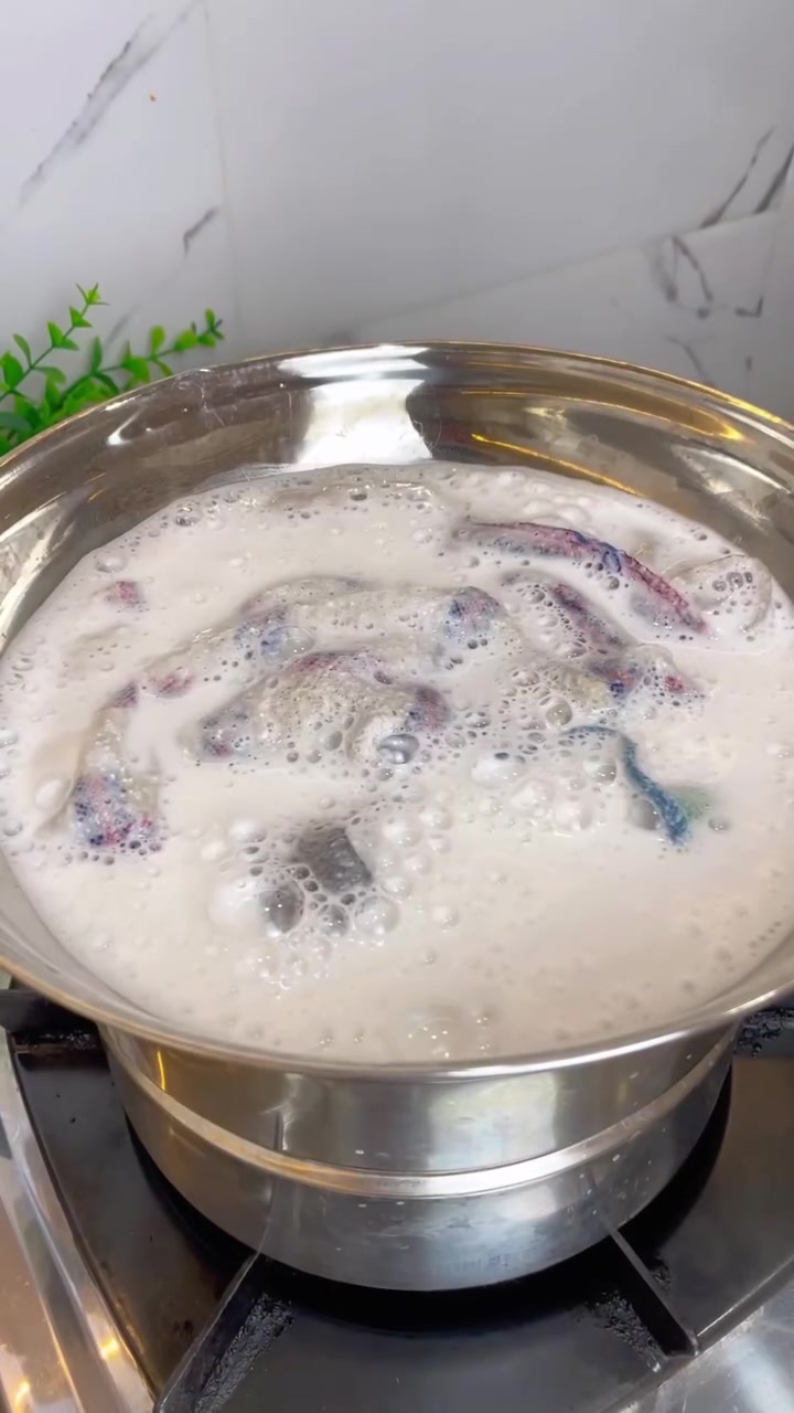Kain dapur direndam dalam air berbusa di dalam periuk stainless atas dapur gas