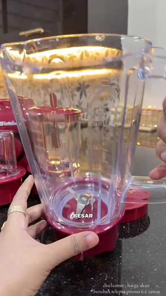 Jar blender besar kosong dengan mata pisau stainless steel kelihatan pada dasar jar merah