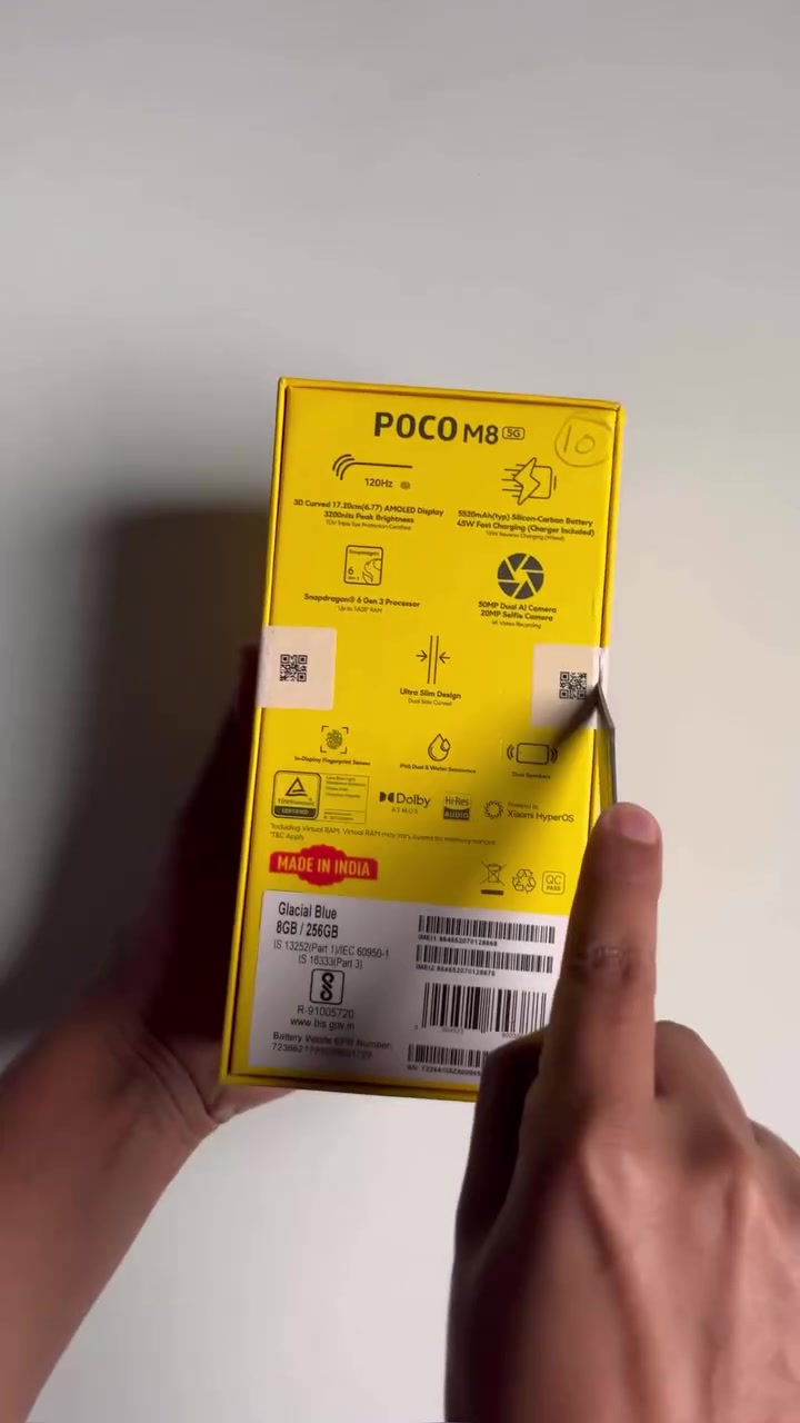 Belakang kotak kuning POCO M8 5G dengan senarai spec tercetak: skrin AMOLED 120Hz, bateri 5520mAh, cas 45W, Snapdragon 6 Gen 3 dan kamera 50MP