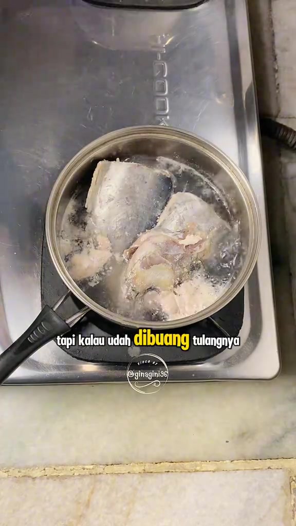 Pot kecil di atas dapur berisi ketul ikan sedang direbus dalam air