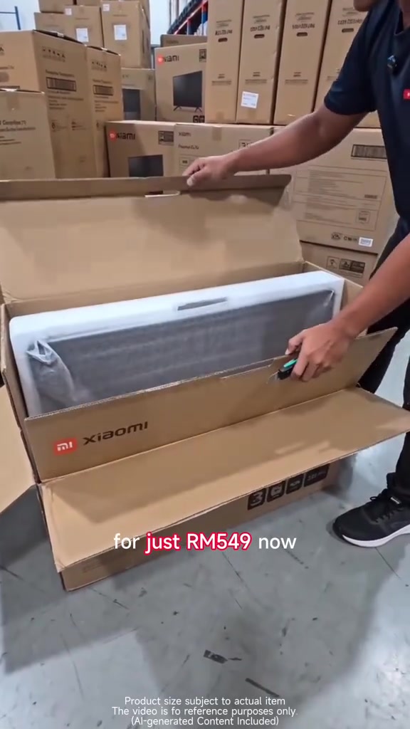 Kotak TV Xiaomi sedang dibuka di gudang dengan teks promosi RM549 dan susunan kotak TV berjenama di latar belakang