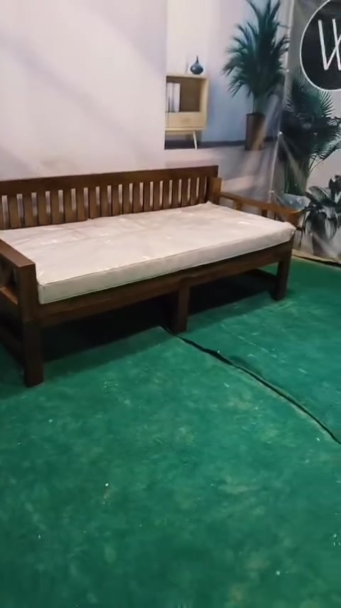 Daybed kayu dengan tilam tatami putih terbentang dalam showroom perabot, tiada orang dalam gambar