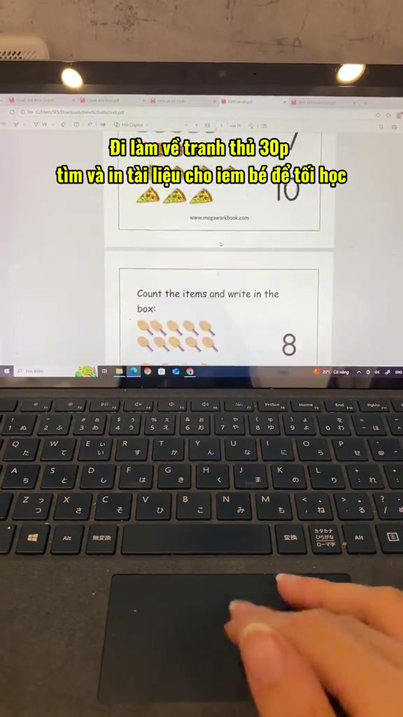 Màn hình laptop mở file PDF phiếu bài tập đếm hình cho trẻ, phía trước là bàn phím, chữ chèn trong ảnh nói phụ huynh đi làm về tranh thủ tìm và in tài liệu cho con học tối