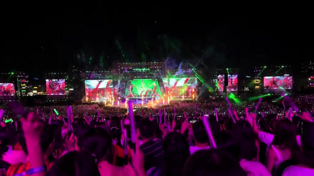 Khán giả nhìn từ phía sau giơ lightstick xanh lá trước sân khấu laser và màn hình lớn đêm Day 2 concert Anh Trai Vượt Ngàn Chông Gai 2026