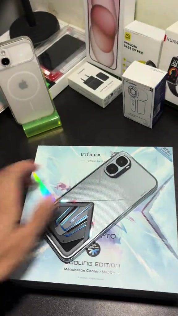 Kotak Infinix GT 50 Pro Cooling Edition di atas meja bersama kotak peranti lain di ruang kedai