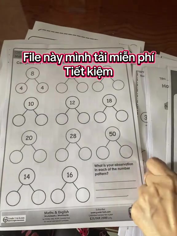 Xấp phiếu bài tập toán đen trắng đã in xếp chồng trên mặt bàn, chữ chèn trong ảnh ghi file tải miễn phí nên tiết kiệm