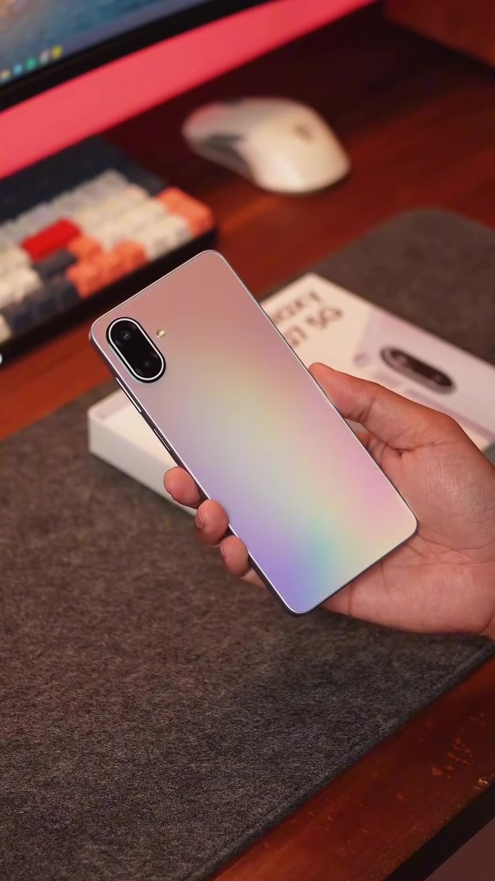 Belakang Samsung Galaxy A07 5G warna gradasi keperakan dipegang di tangan, modul dua kamera menegak kelihatan