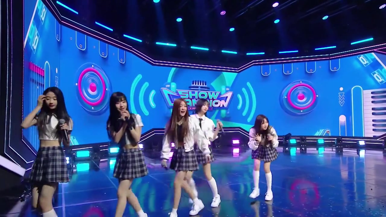 Góc máy rộng sân khấu Show Champion ngày 21/10: năm thành viên A2O LITE cầm micro hát encore trên nền màn hình logo chương trình màu xanh
