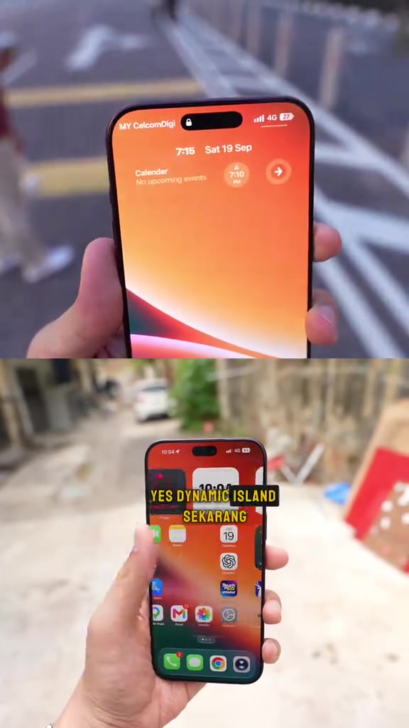 Skrin kunci iPhone 18 menunjukkan nama rangkaian MY CelcomDigi di penjuru atas, dipegang dengan satu tangan di luar bangunan