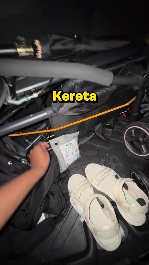 Beg arang bambu kecil diletak di but kereta sebelah stroller lipat dan sandal
