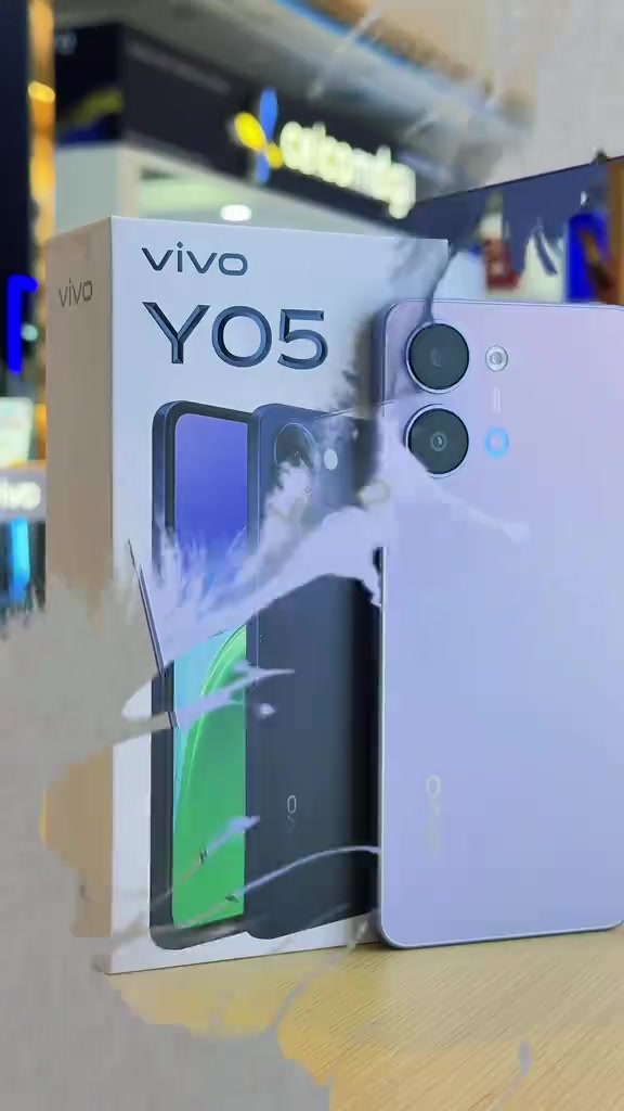 Kotak vivo Y05 berdiri sebelah unit warna ungu muda di kaunter dealer dalam pusat membeli-belah