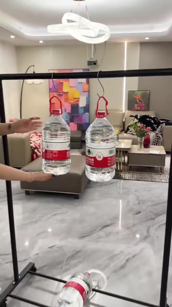 Dua botol air 5 liter digantung pada satu bar rak baju besi sebagai ujian beban