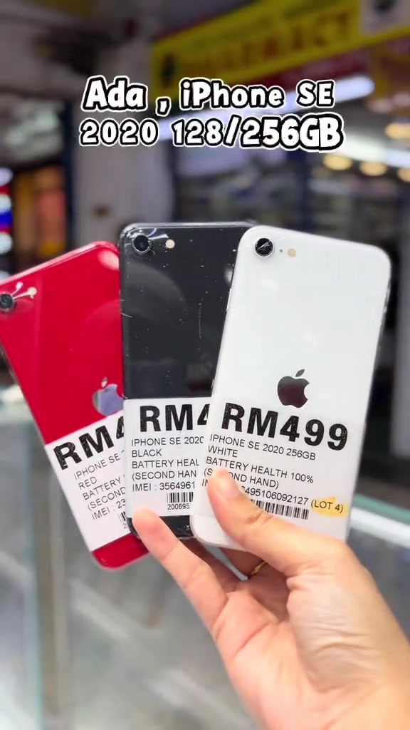 Tiga iPhone SE 2020 merah, hitam dan putih dipegang serentak dengan tag harga RM459 hingga RM499 yang memaparkan battery health 100% dan nombor IMEI