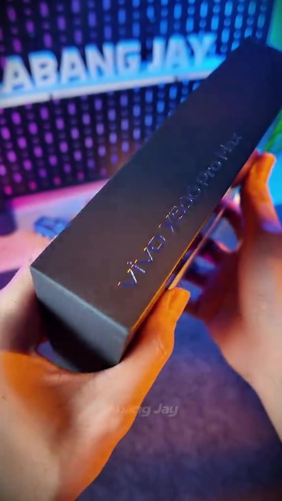 Kotak hitam vivo X500 Pro Max dipegang dua tangan dengan tulisan model timbul pada sisi kotak
