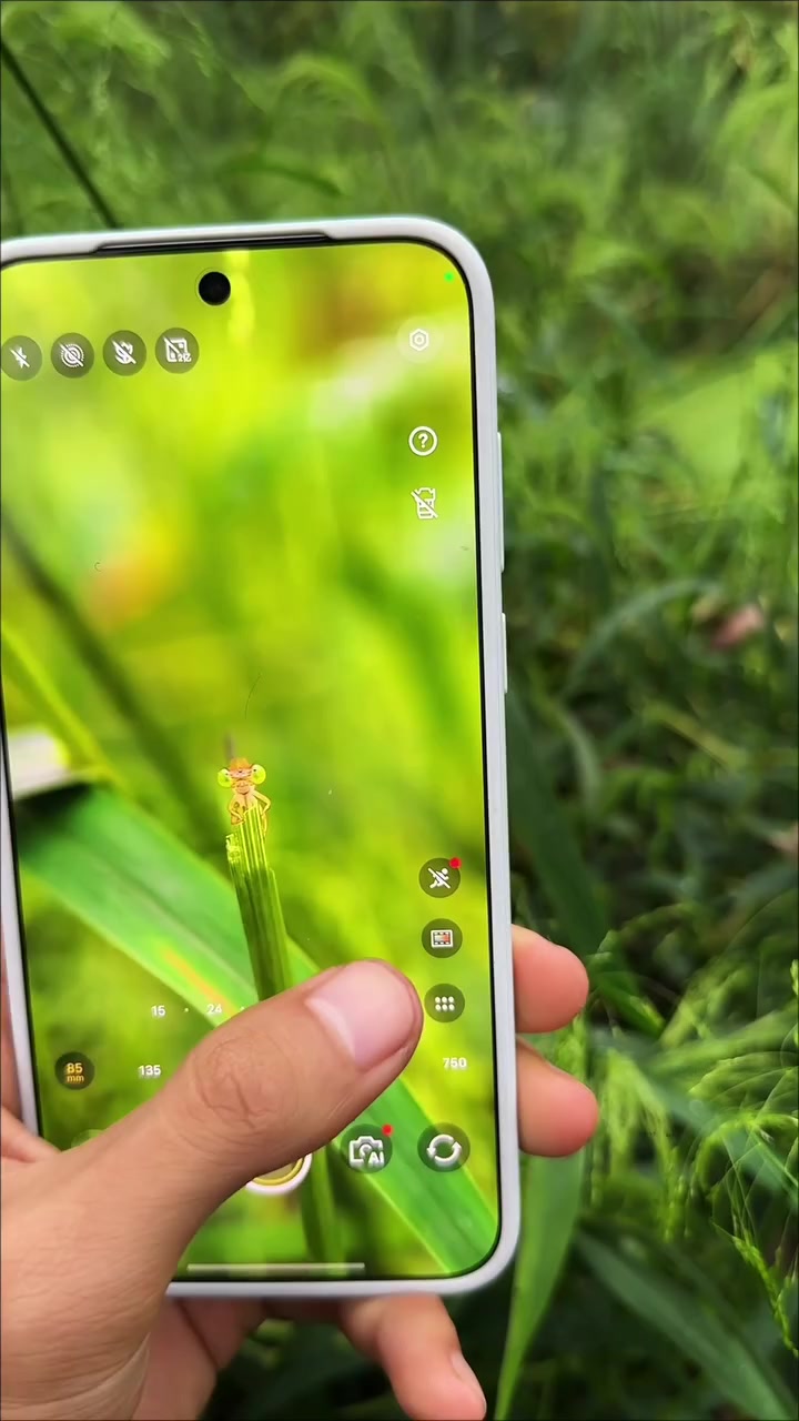 vivo X500 Pro Max warna putih dipegang dengan latar rumput hijau, app kamera terbuka