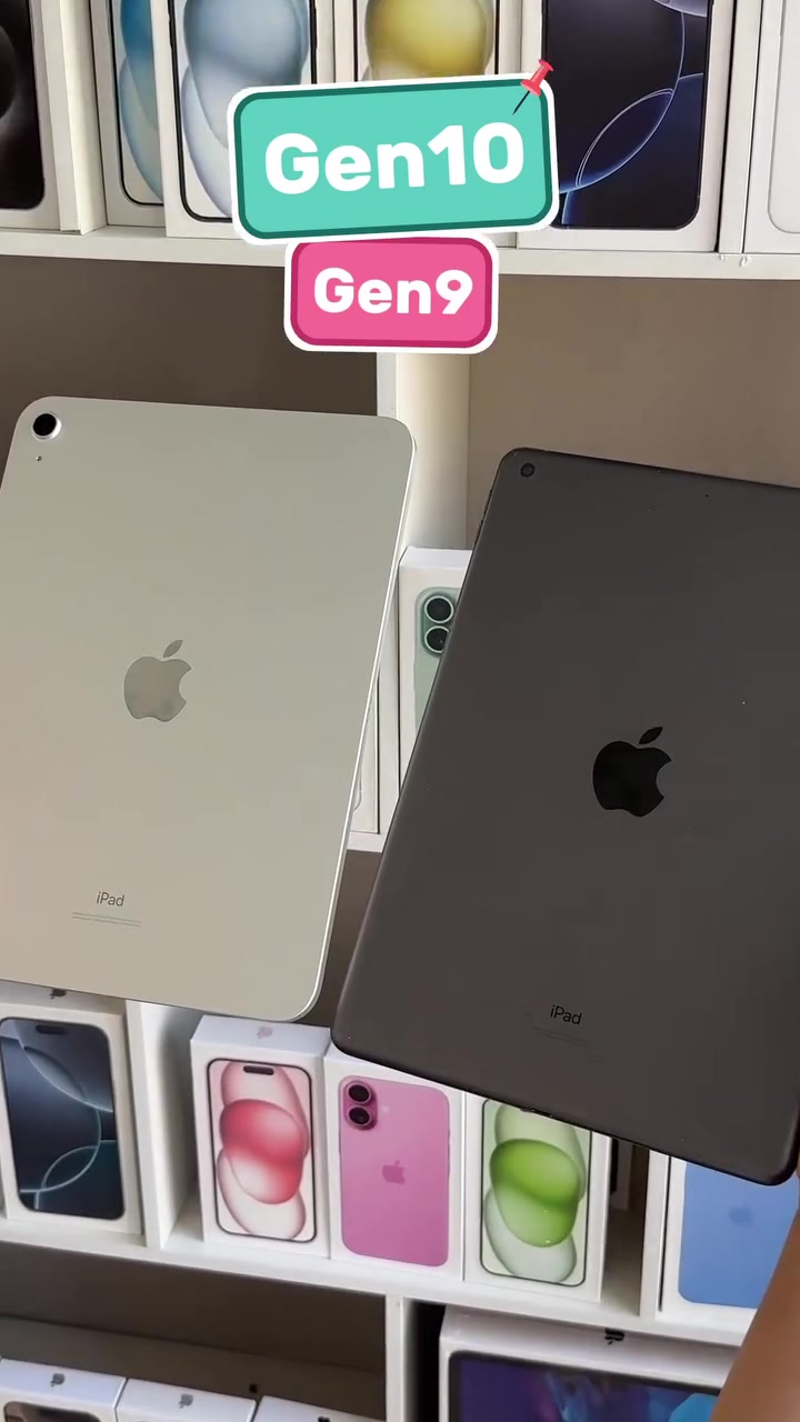 Hai chiếc iPad đặt cạnh nhau khoe mặt lưng, một bản màu bạc và một bản màu xám, phía sau là kệ trưng bày hộp iPhone