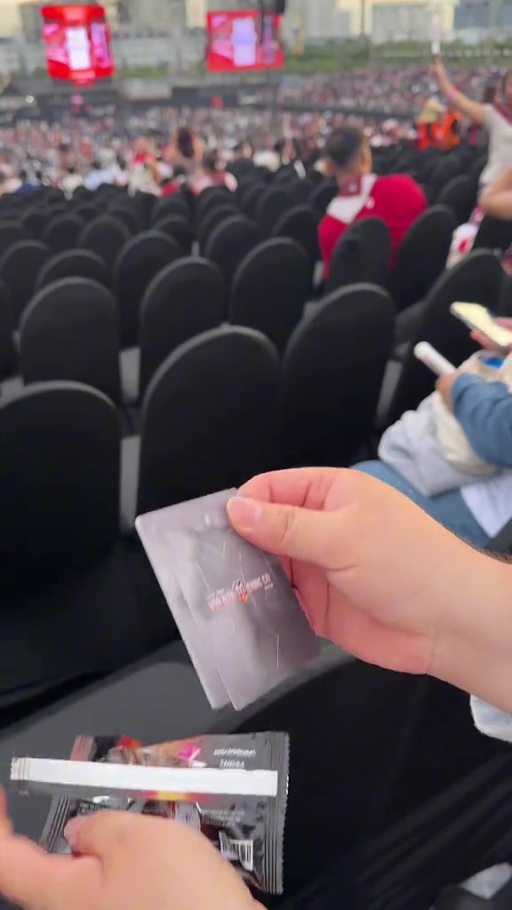 Hàng ghế bọc vải đen còn trống trước giờ diễn tại khu seated, phía xa là khán đài và màn hình đỏ của concert Anh Trai Vượt Ngàn Chông Gai 2026