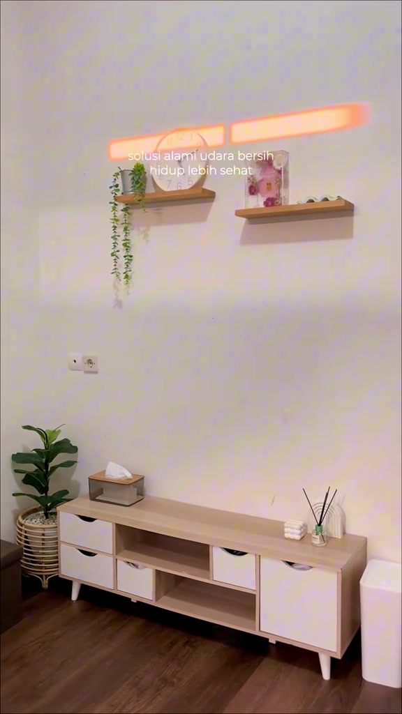 Ruang tamu terbuka dengan konsol TV putih dan rak dinding kayu berhiasan tanaman