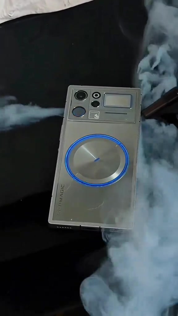 Bahagian belakang REDMAGIC 12 Pro warna perak dengan cincin kipas bercahaya biru dikelilingi wap sejuk