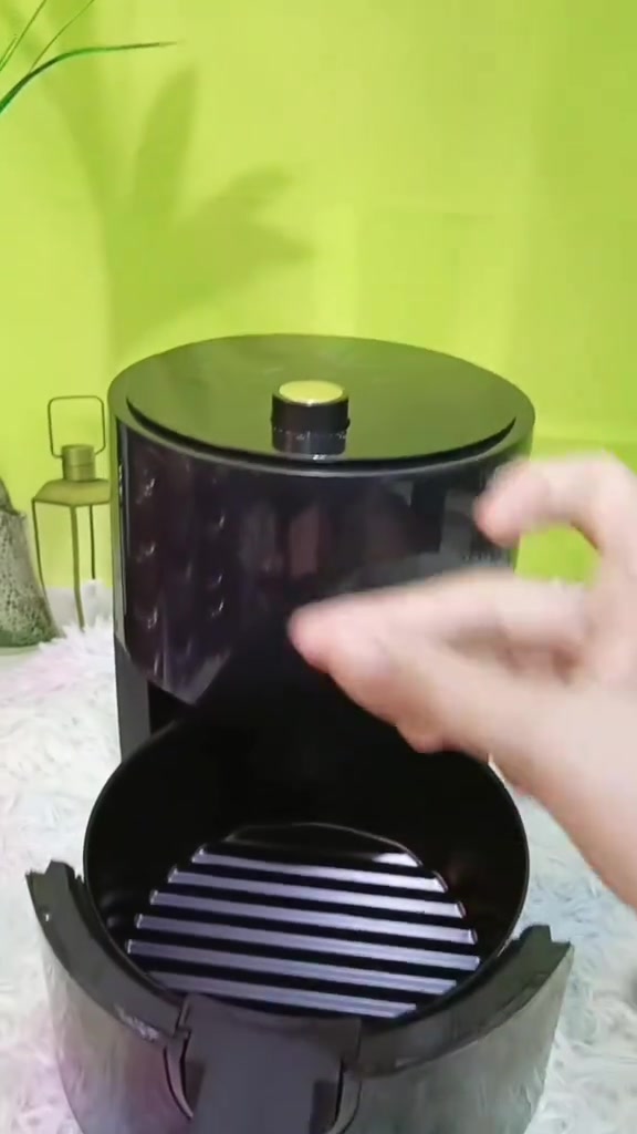 Air fryer hitam bulat dengan bakul ditarik keluar menampakkan rak grill di dalam