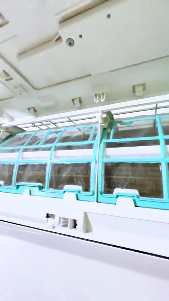 Filter aircond rangka turquoise yang bersih dipasang semula dalam unit dinding