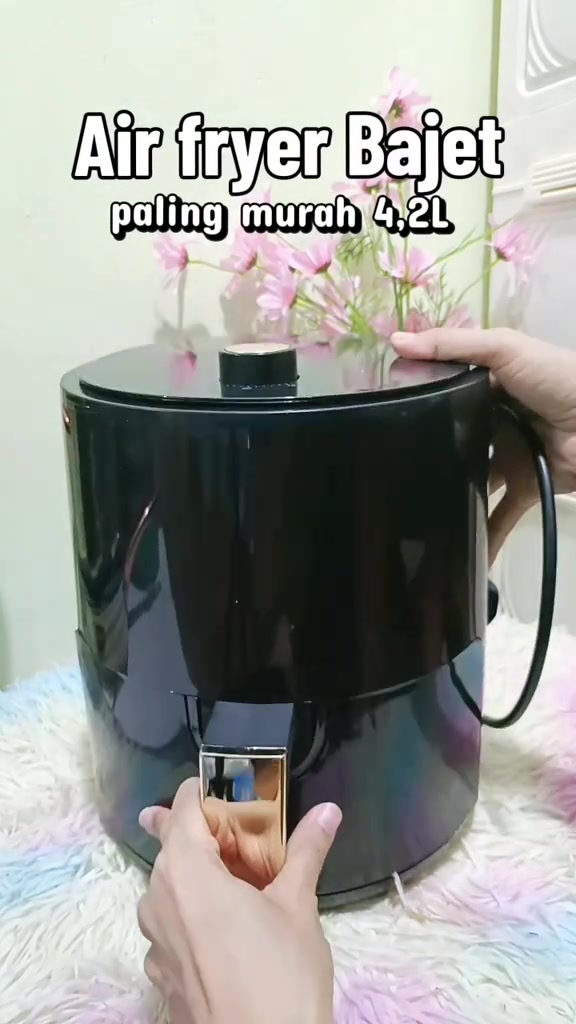 Air fryer bajet 4.2L badan hitam berkilat dengan tombol emas di atas, dipegang dua tangan