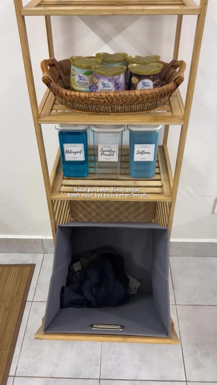 Para rak buluh dengan bakul anyaman berisi balang pewangi, bekas berlabel Detergent, Laundry Powder dan Softener, serta bakul tilt berisi baju kotor