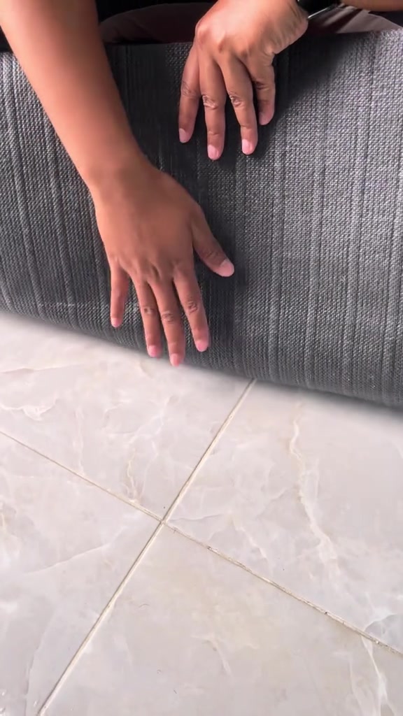 Tangan menekan permukaan belakang getah kelabu runner dapur yang digulung, menunjukkan tapak getah tebal