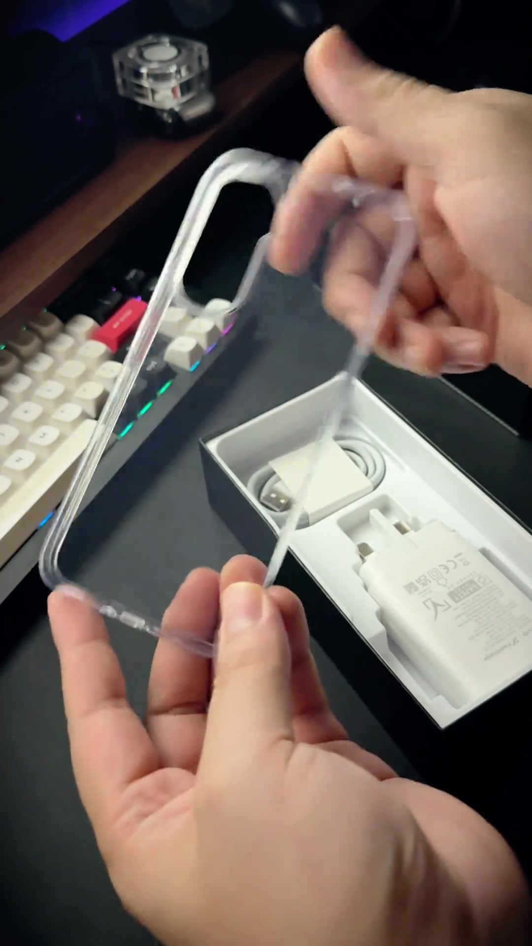 Kotak iQOO Z11 5G terbuka dengan casing jelas di tangan serta charger dan kabel di dalam kotak