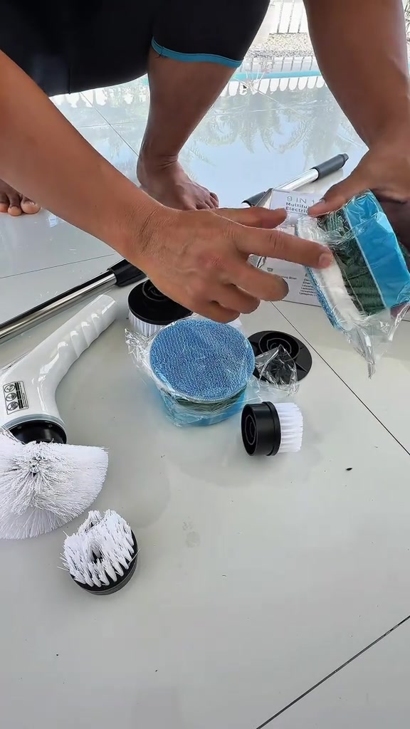 Set berus elektrik terbentang atas lantai jubin: pemegang putih, batang sambung besi, berus bulat besar, berus sudut, berus kecil, pad microfiber biru dan pad scotch hijau
