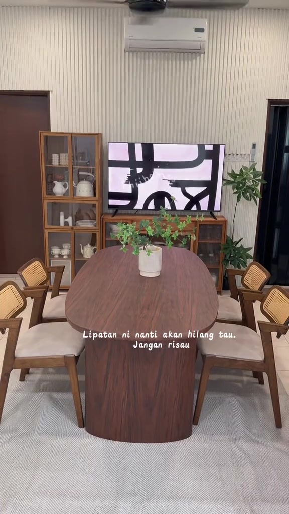 Karpet fabrik beige bercorak herringbone terbentang bawah meja makan kayu oval dalam ruang makan berdinding panel