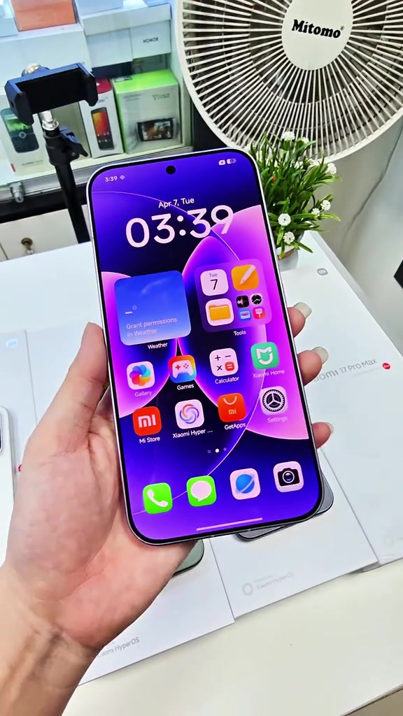 Mặt trước Xiaomi 17 Pro Max cầm trên tay, màn hình home hiện các icon HyperOS bằng tiếng Anh như Mi Store, GetApps, Gallery