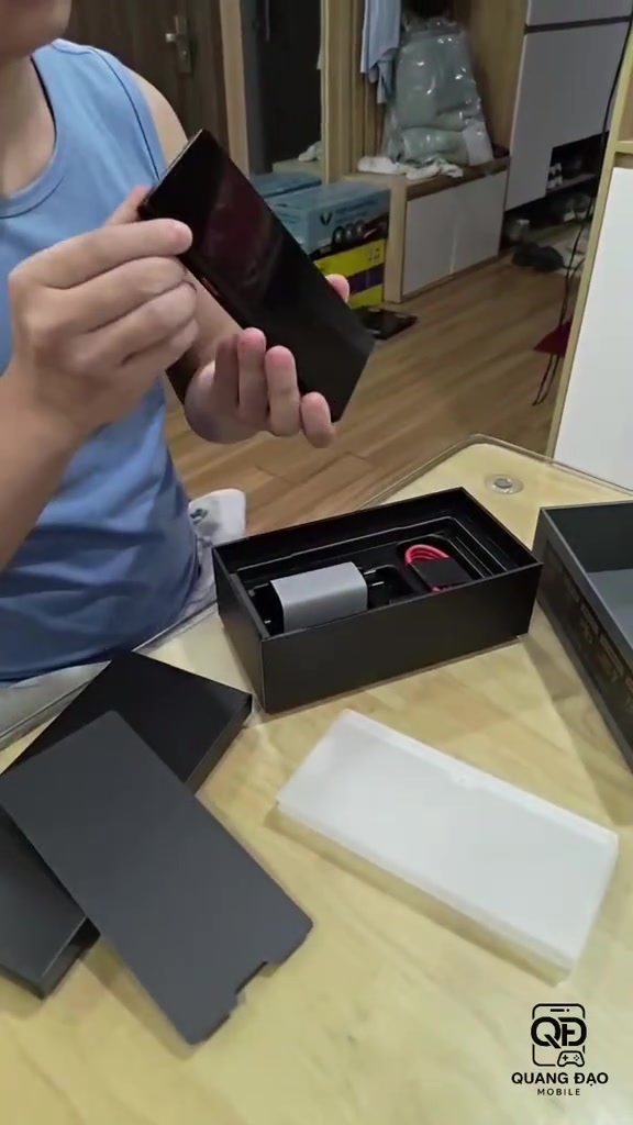 Hộp RedMagic 12 Pro+ mở trên bàn với củ sạc, cáp màu đỏ và thân máy màu đen bên cạnh