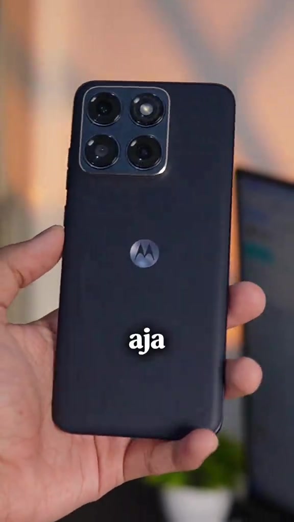 Phone Motorola warna hitam dipegang satu tangan dengan logo M kelihatan pada belakang badan