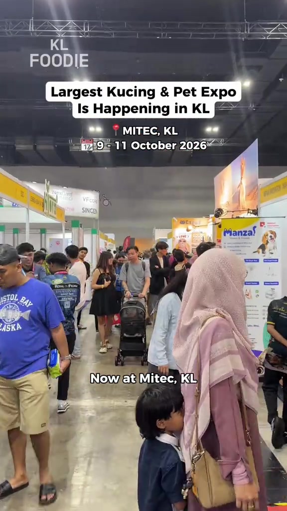 Dewan ekspo kucing yang penuh pengunjung dengan deretan booth dan stroller kucing di tengah lorong