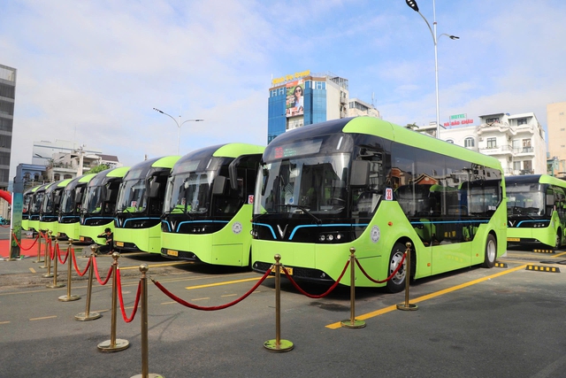 Hàng xe buýt điện VinBus màu xanh lá đậu thẳng hàng trong bãi đỗ có dây chắn đỏ