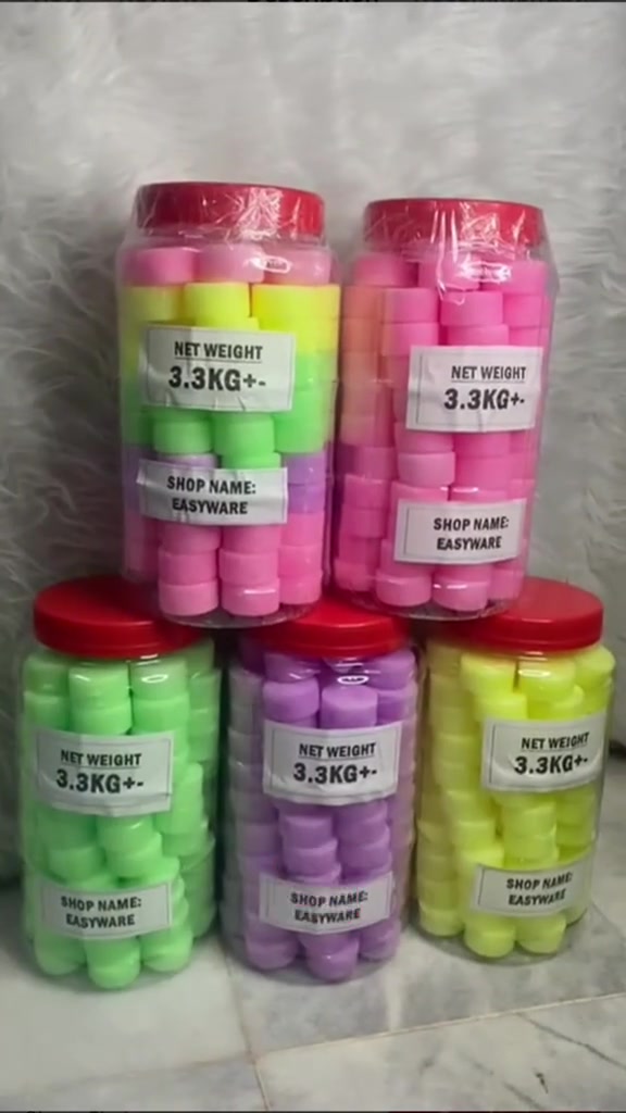 Lima balang plastik berpenutup merah berisi tablet pewangi pelbagai warna merah jambu, hijau, ungu dan kuning disusun bertingkat