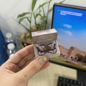 Hộp sạc Dmooster D95 màu hồng mở ra trên tay, nền là màn hình máy tính