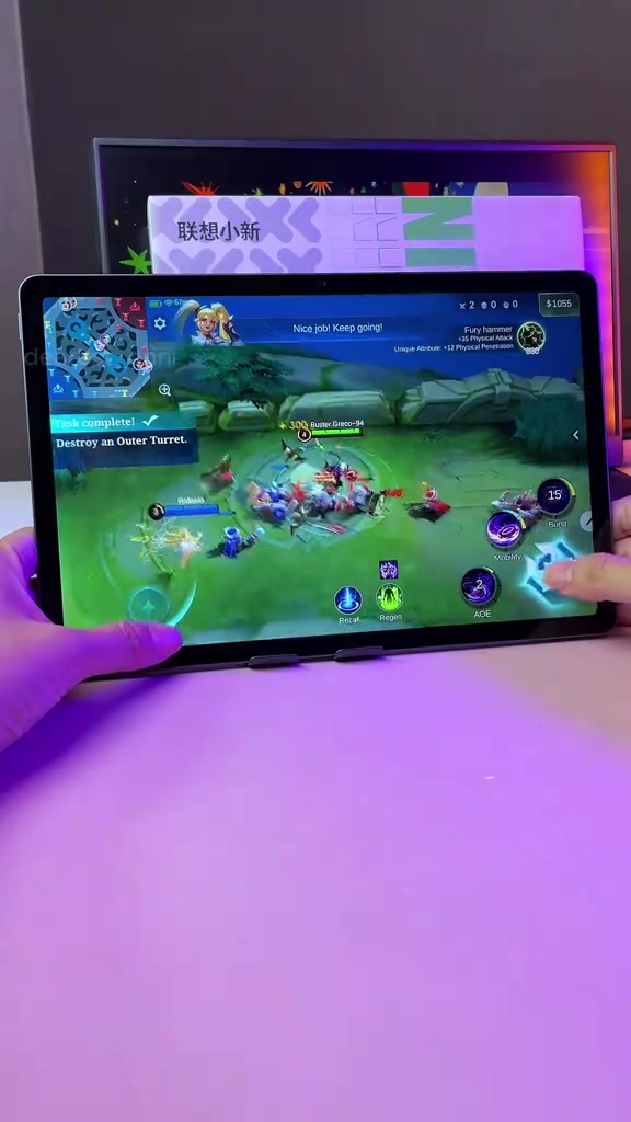 Lenovo Idea Tab dipegang melintang sedang menjalankan game MOBA dengan butang kawalan di skrin