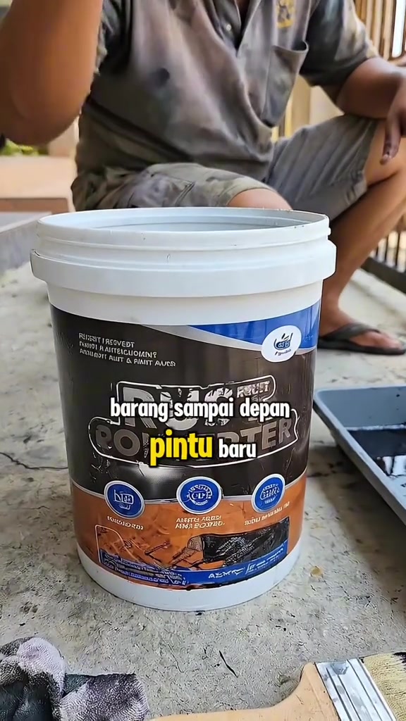 Baldi cat rust converter diletak di lantai konkrit sebelah tray cat, sarung tangan dan berus