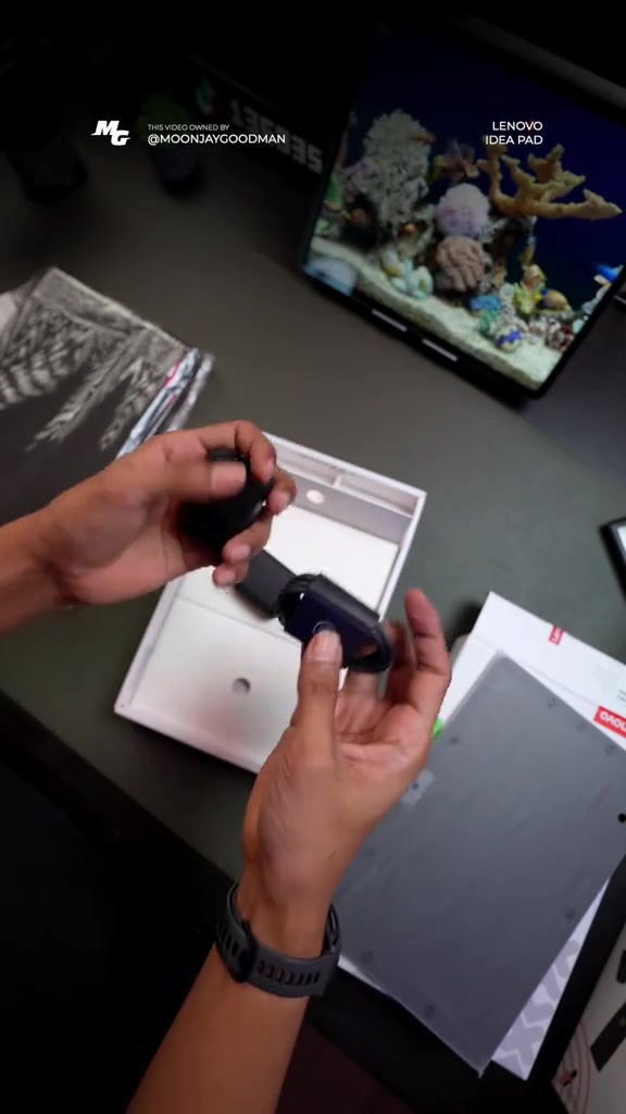 Tangan memegang penyesuai kuasa 20W di atas kotak Lenovo Idea Tab yang sedang dibuka semasa unboxing